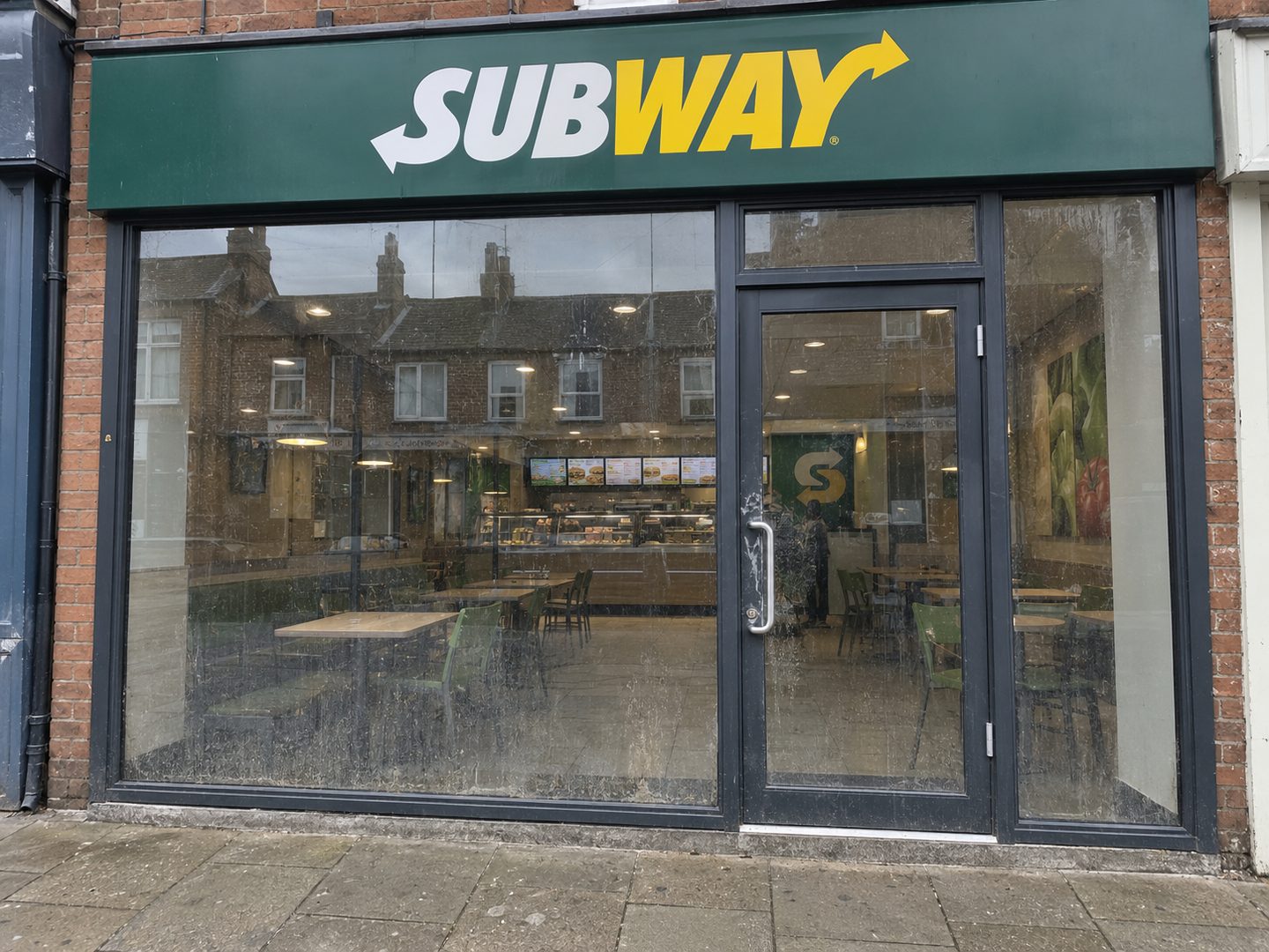 A shopfront before cleaning, the glass streaked and dulled