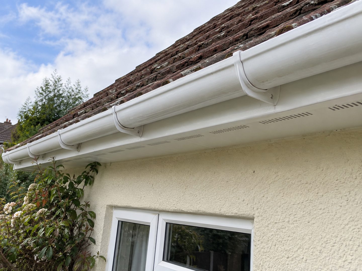 White uPVC fascia, soffit and gutter cleaned along a bungalow roofline